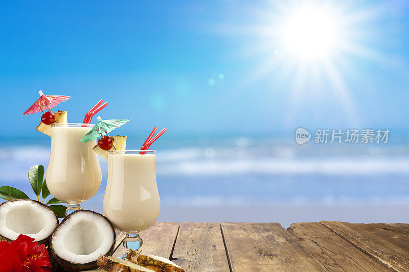 两个Piña Colada杯在阳光明媚的海滩